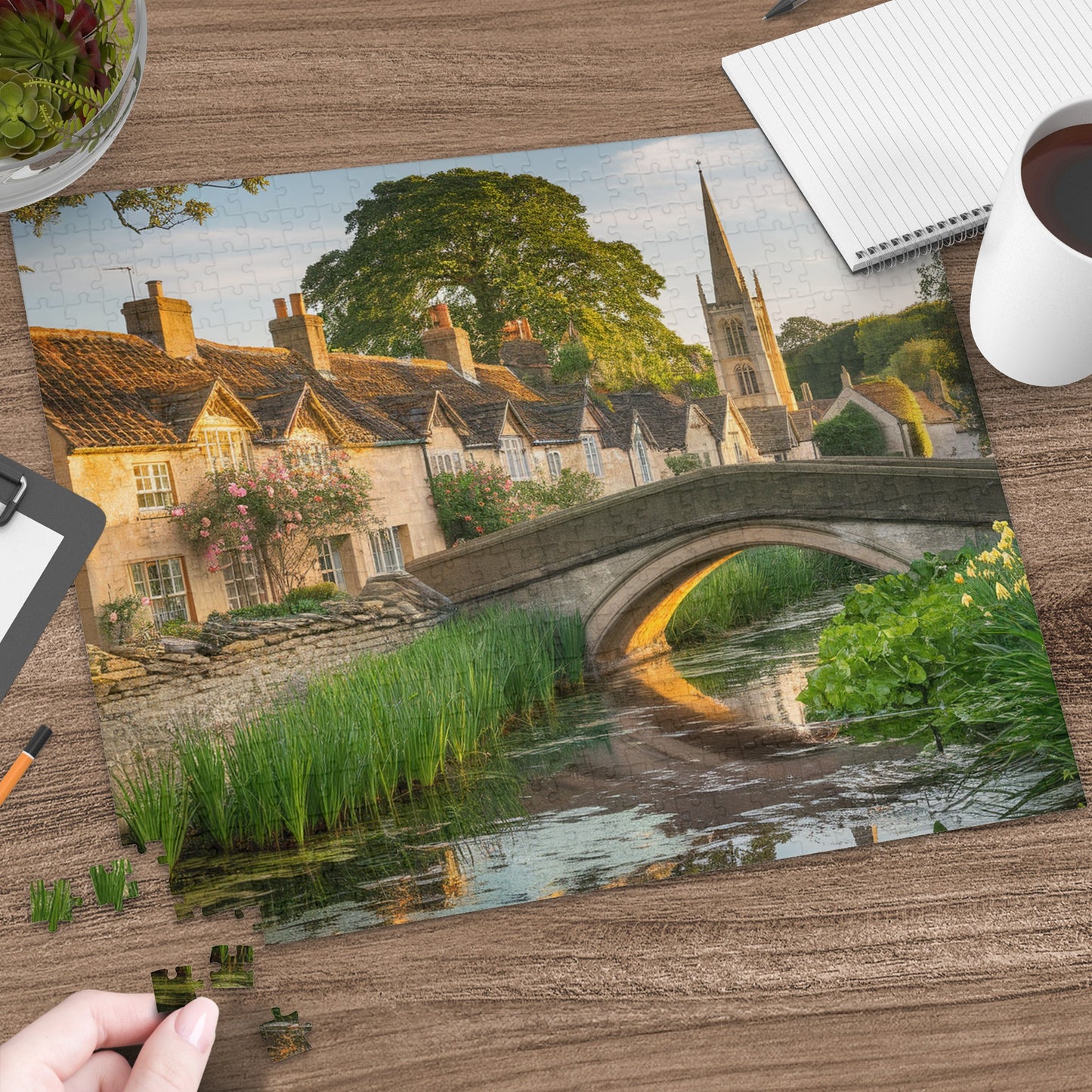 Jigsaw puzzle pieces forming a picturesque village scene with a bridge over a canal.
