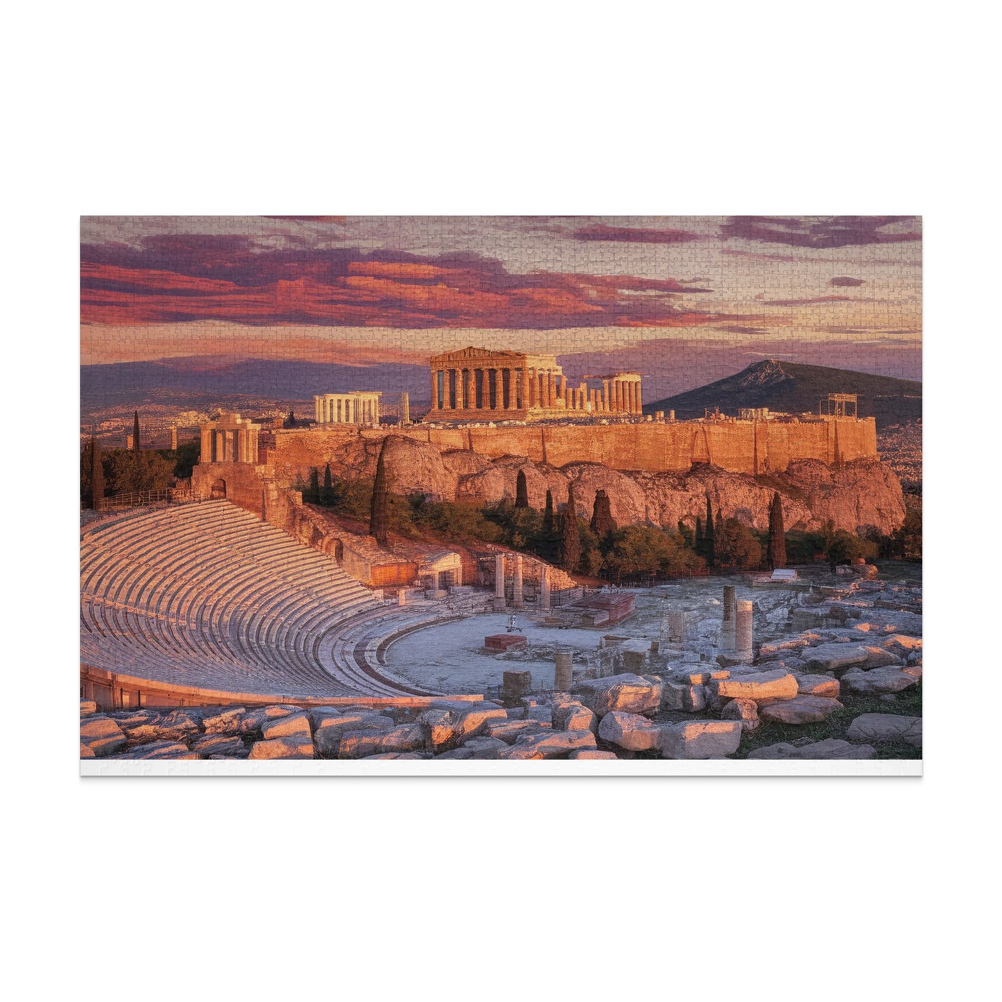 Ancient Greek amphitheater and Acropolis at sunset with vibrant clouds.