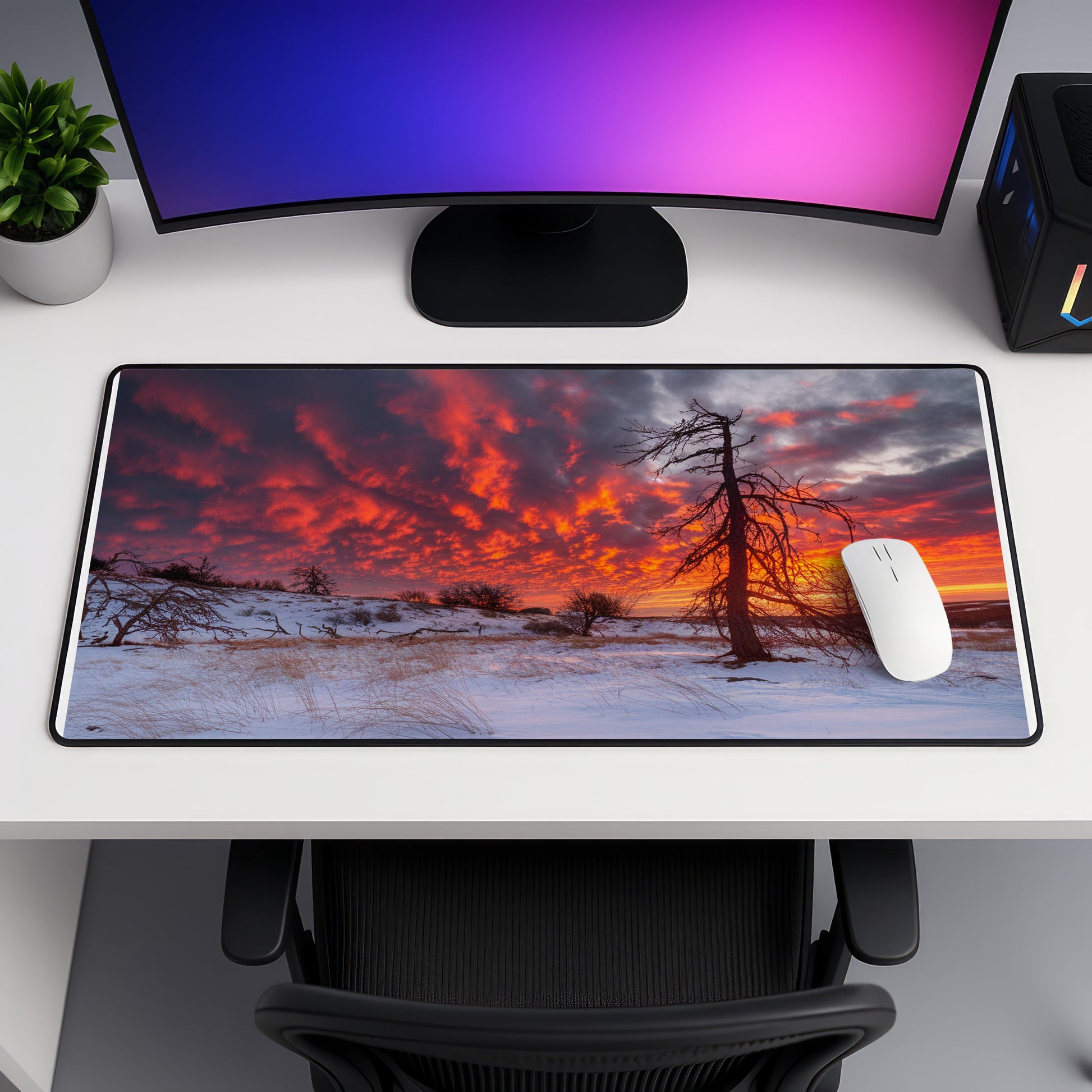 Mousepad with sunrise over snowy landscape and silhouetted trees.