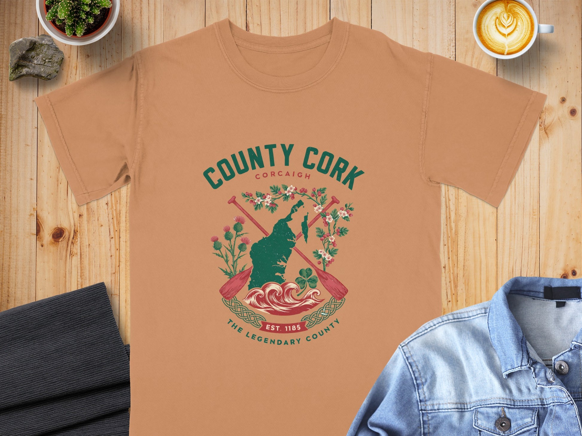 County Cork graphic with map, oars, flowers, and waves on a tan t-shirt.