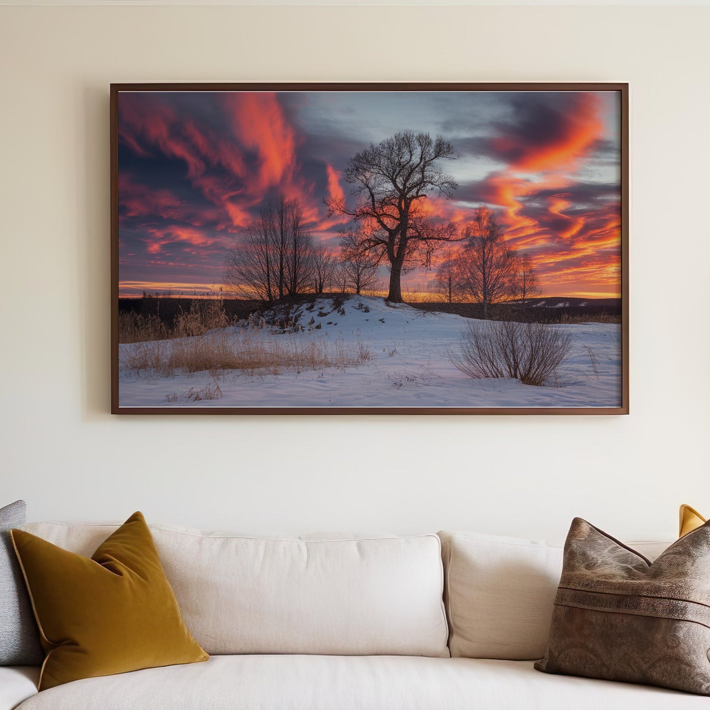 Framed artwork depicting a tree on a snowy hill at sunset.