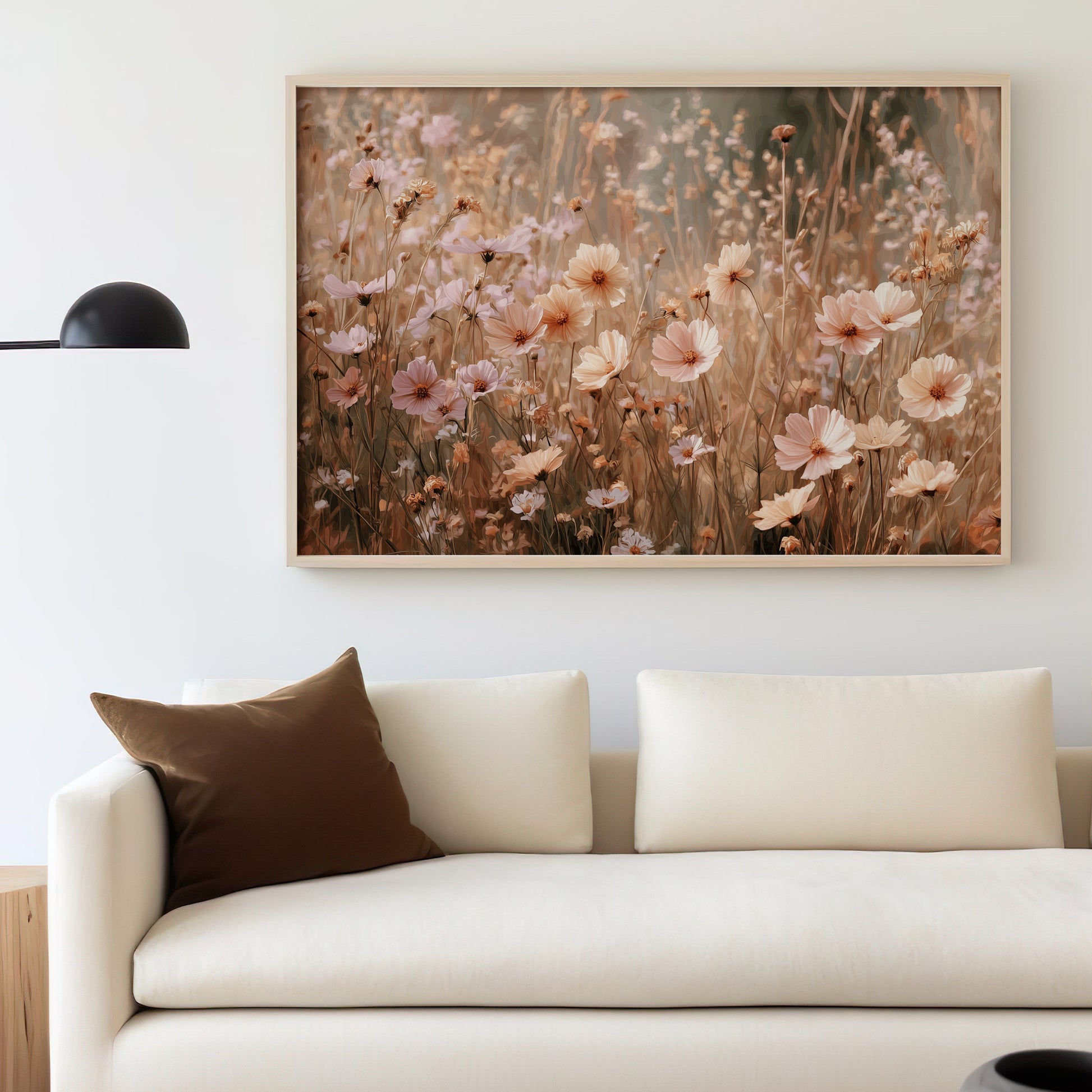 Framed floral artwork above a cream sofa with a brown throw pillow.