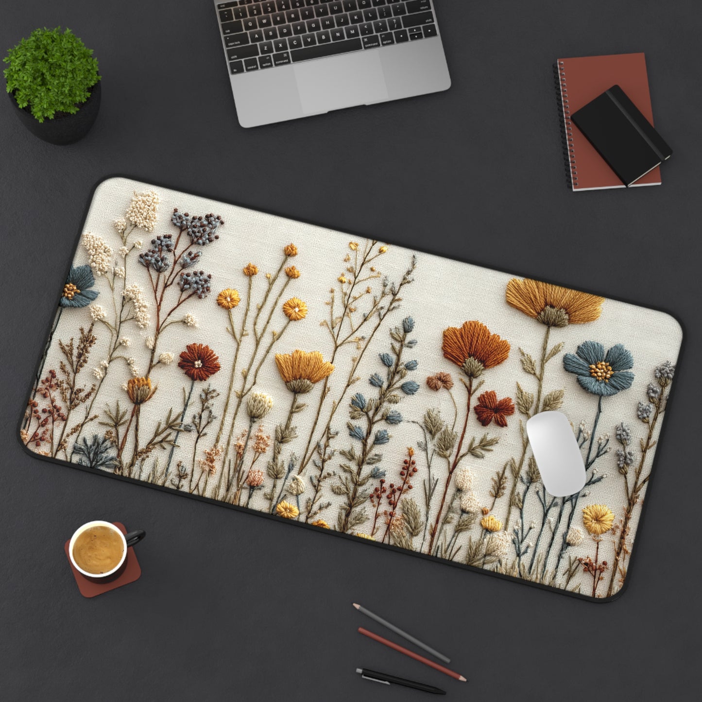 Floral design mouse pad on a dark surface with laptop, cup, and stationery items.