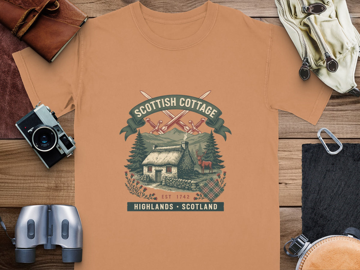T-shirt with Scottish cottage, deer, and swords graphic; text reads "Scottish Cottage Highlands Scotland Est 1742".