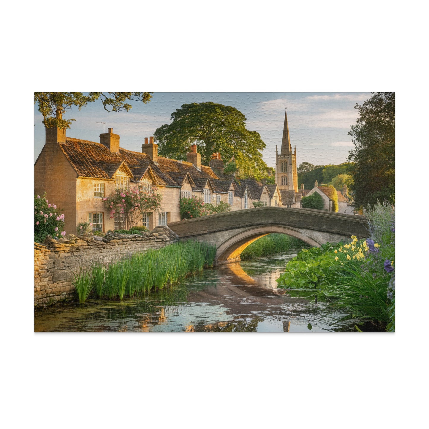 Quaint stone bridge over a canal with village and church in background.
