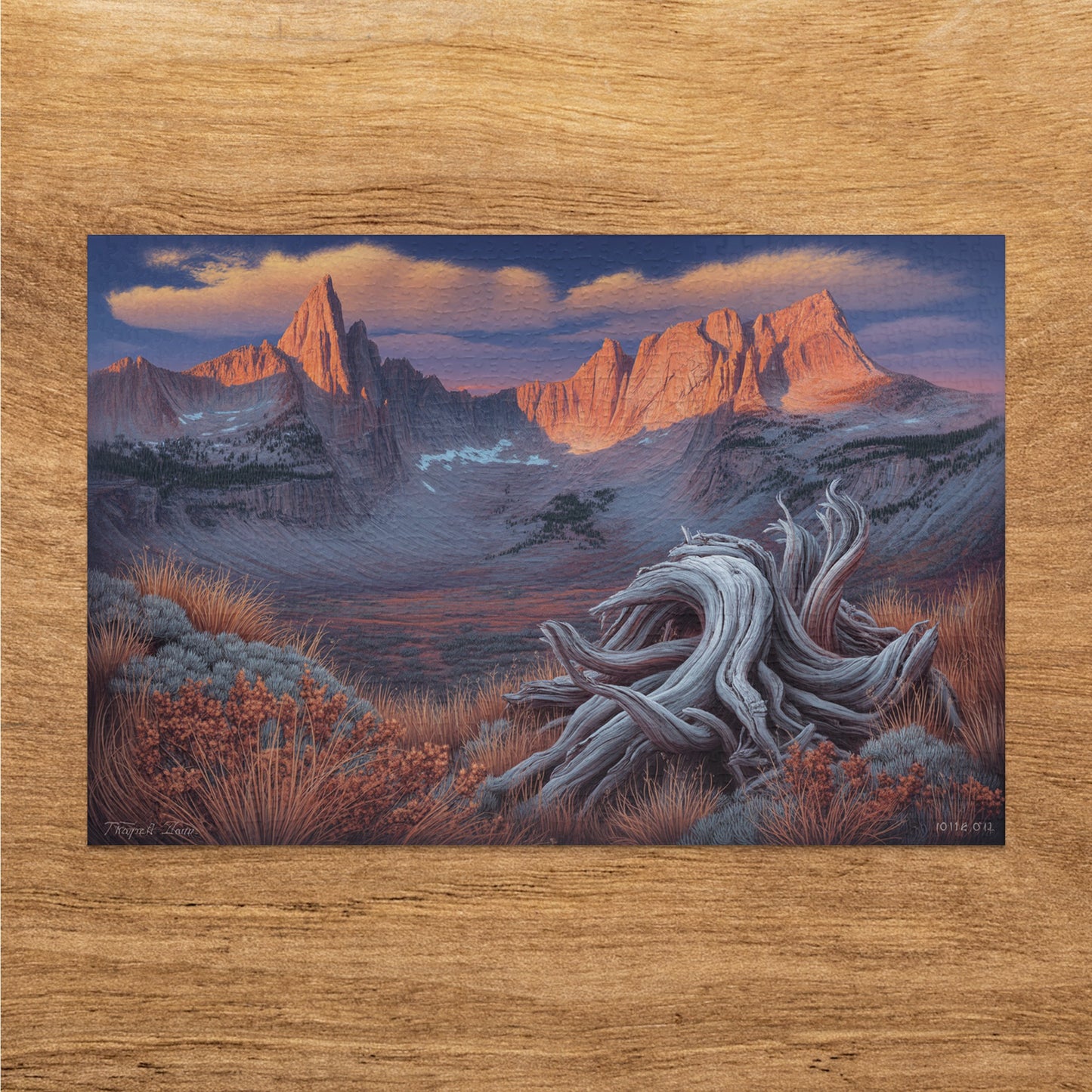 Weathered wood sculpture in foreground with sunlit mountains and dramatic sky in background.
