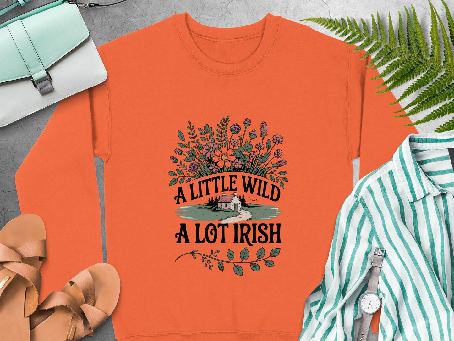 Orange sweatshirt with a floral design and text that reads "A Little Wild A Lot Irish".