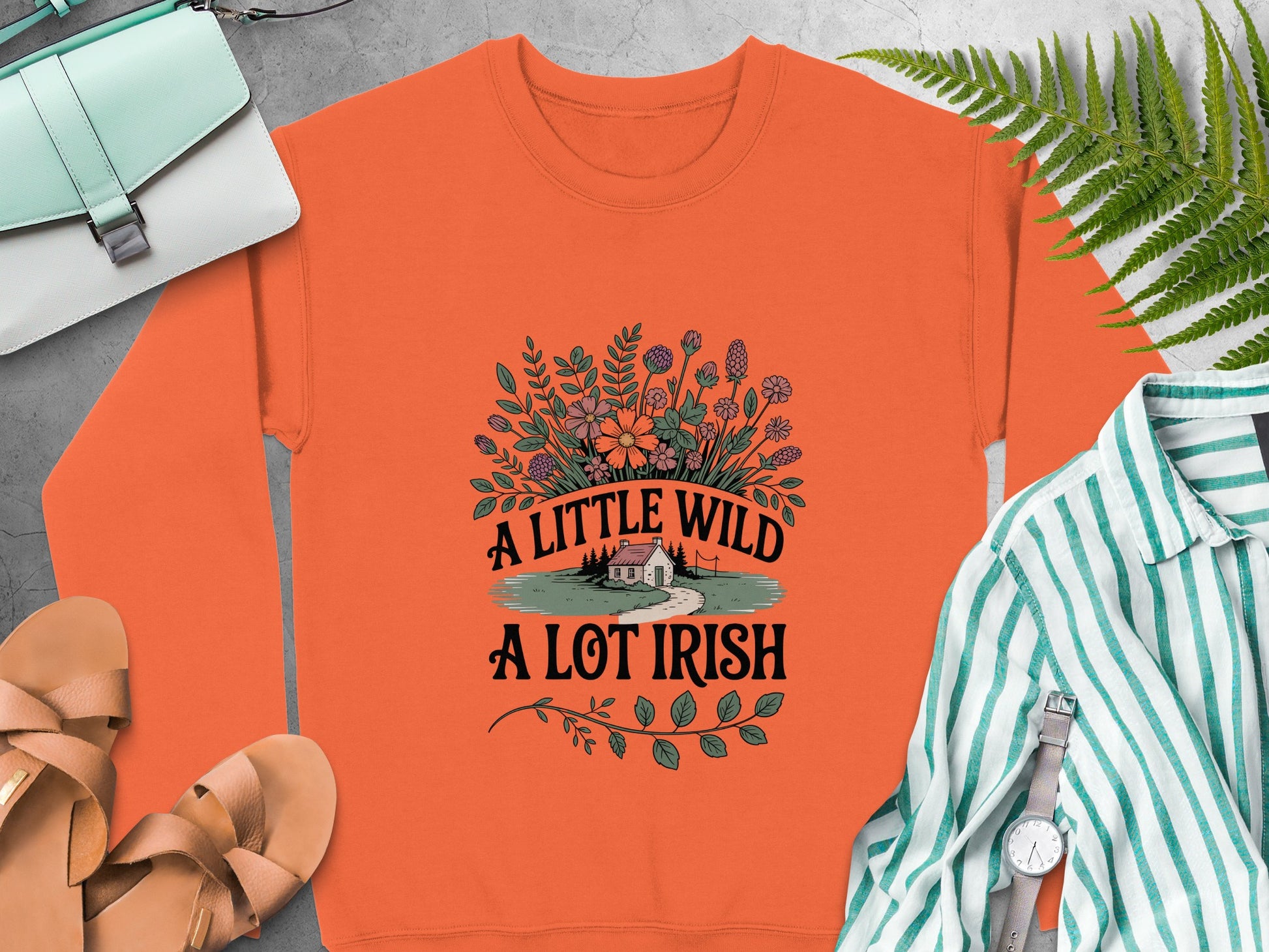 Orange sweatshirt with a floral design and text that reads "A Little Wild A Lot Irish".