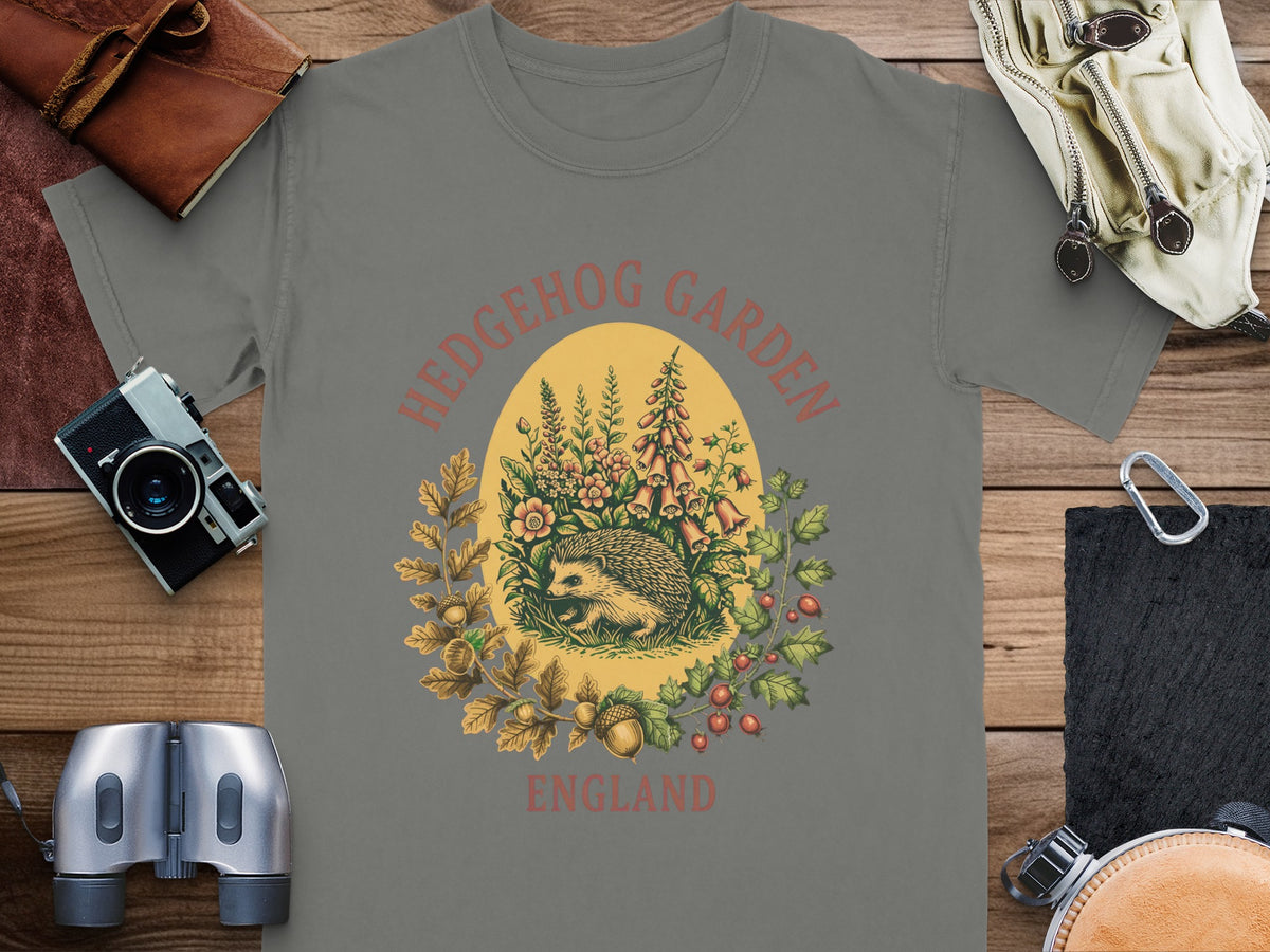 T-shirt with a hedgehog, flowers, acorns, and text reading "HEDGEHOG GARDEN ENGLAND".