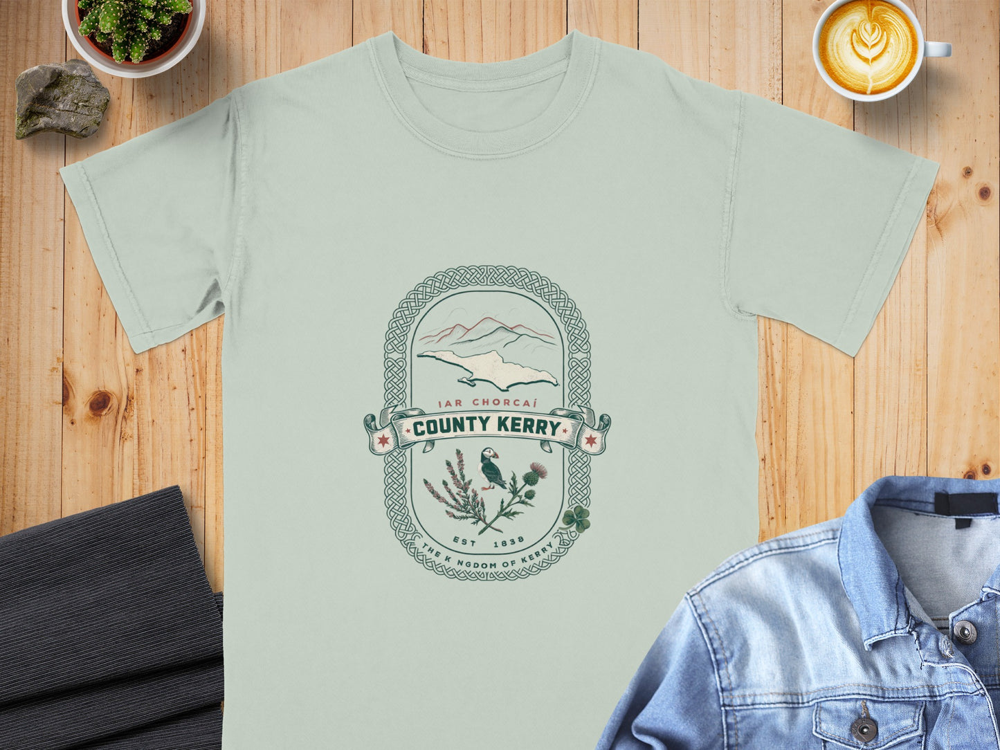 Light green t-shirt with "County Kerry" design featuring mountains, puffin, and thistle.