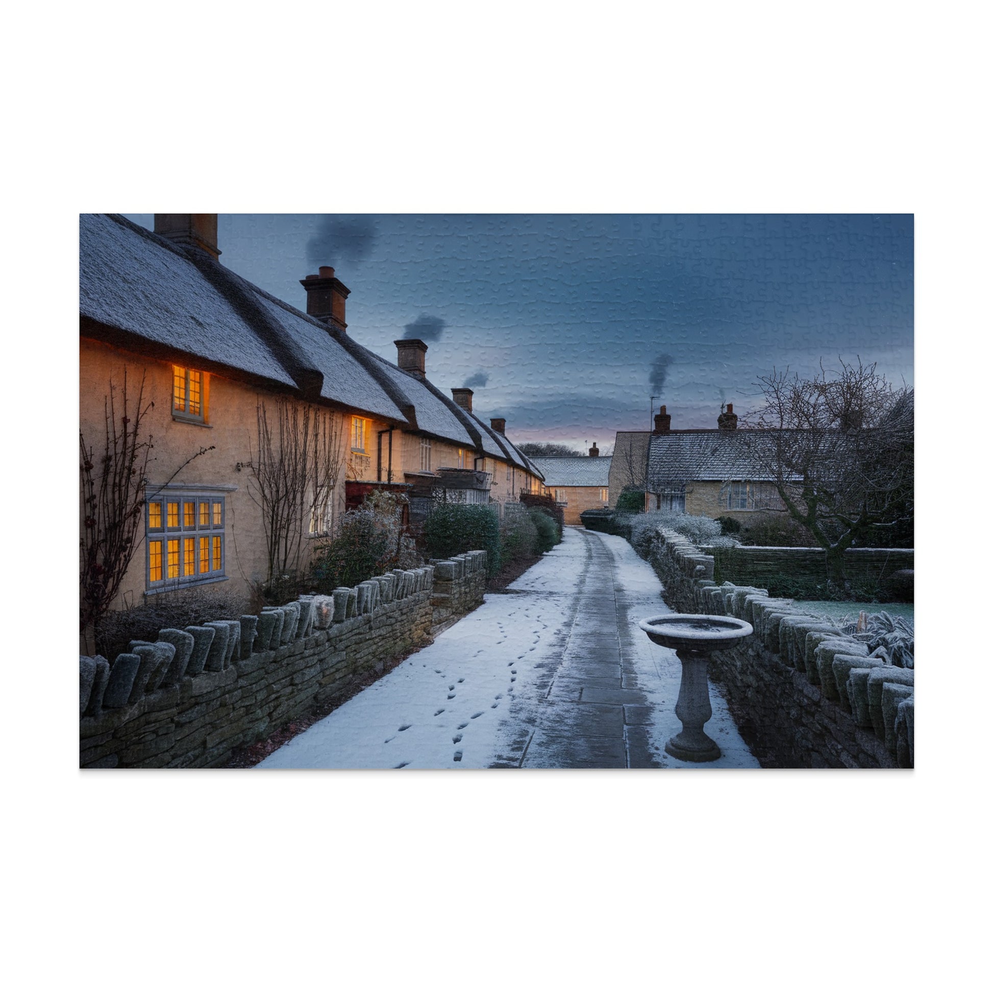 Thatched-roof cottages with glowing windows on a snowy path at dusk.