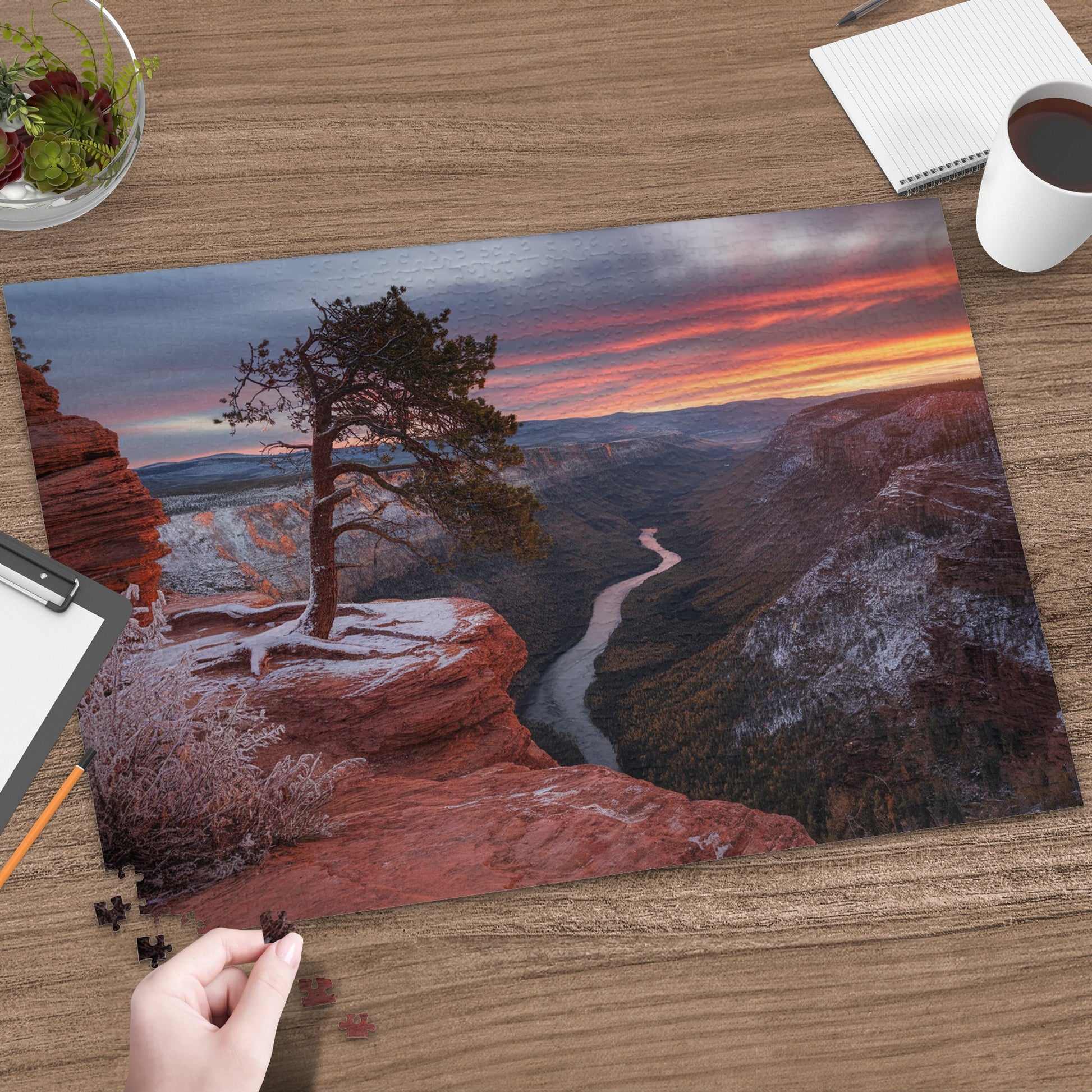 Canyon landscape puzzle with a single tree on a snowy cliff at sunrise.
