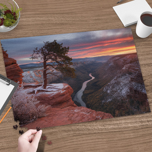 Canyon landscape puzzle with a single tree on a snowy cliff at sunrise.