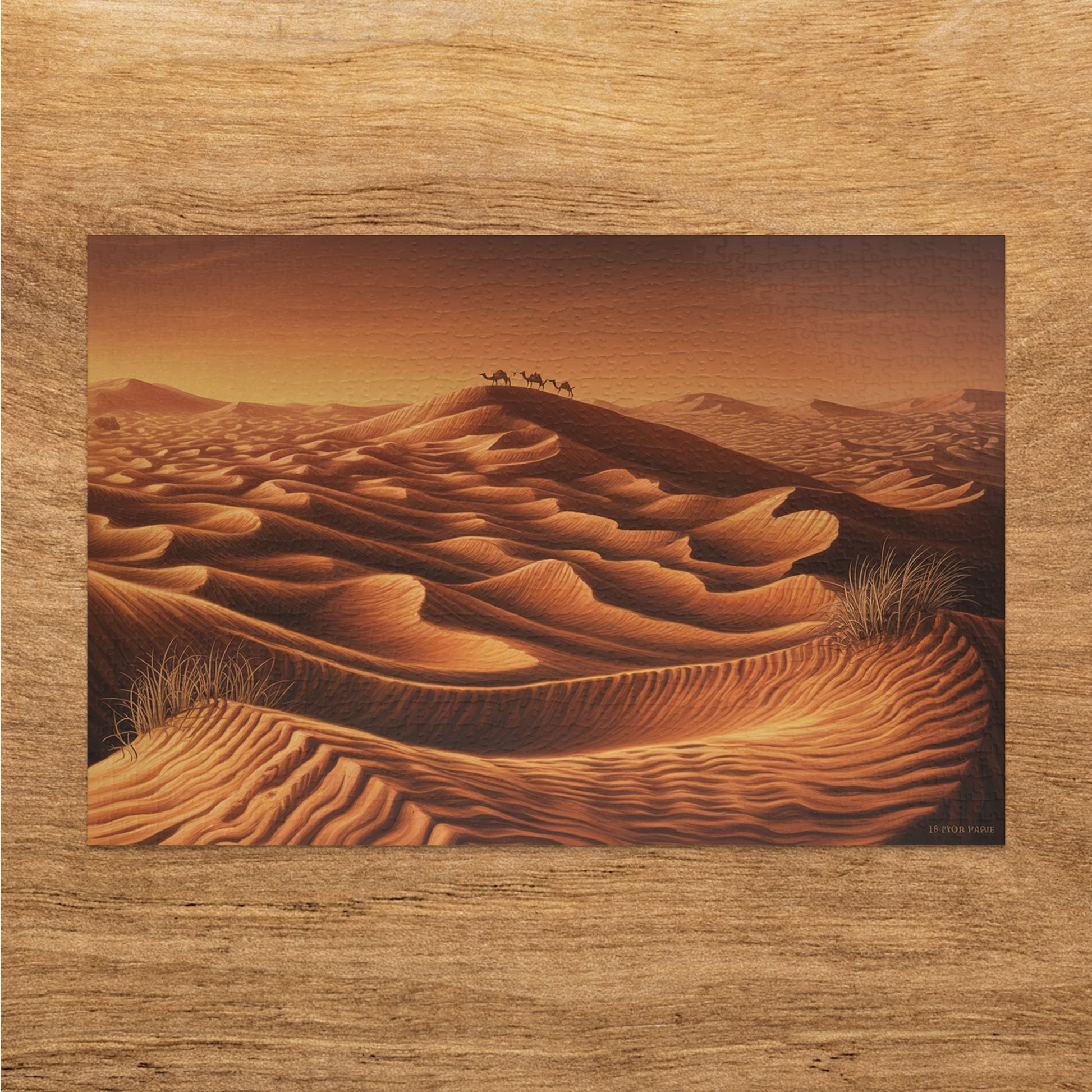 A caravan of camels walks over rolling sand dunes at sunset, with artist's signature in corner.
