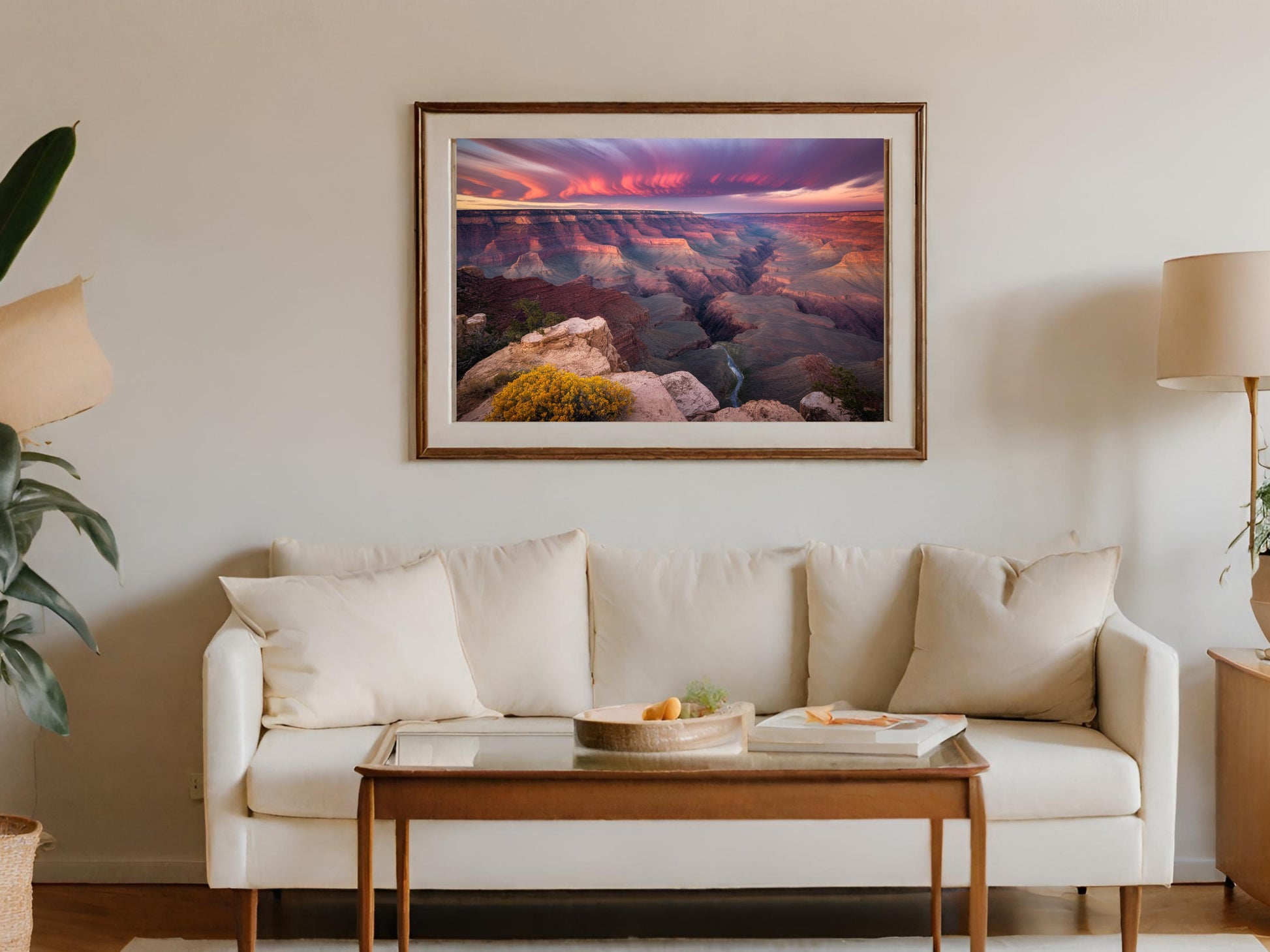 Framed "Grand Canyon at Sunset" art hanging above a cream sofa with wooden coffee table.