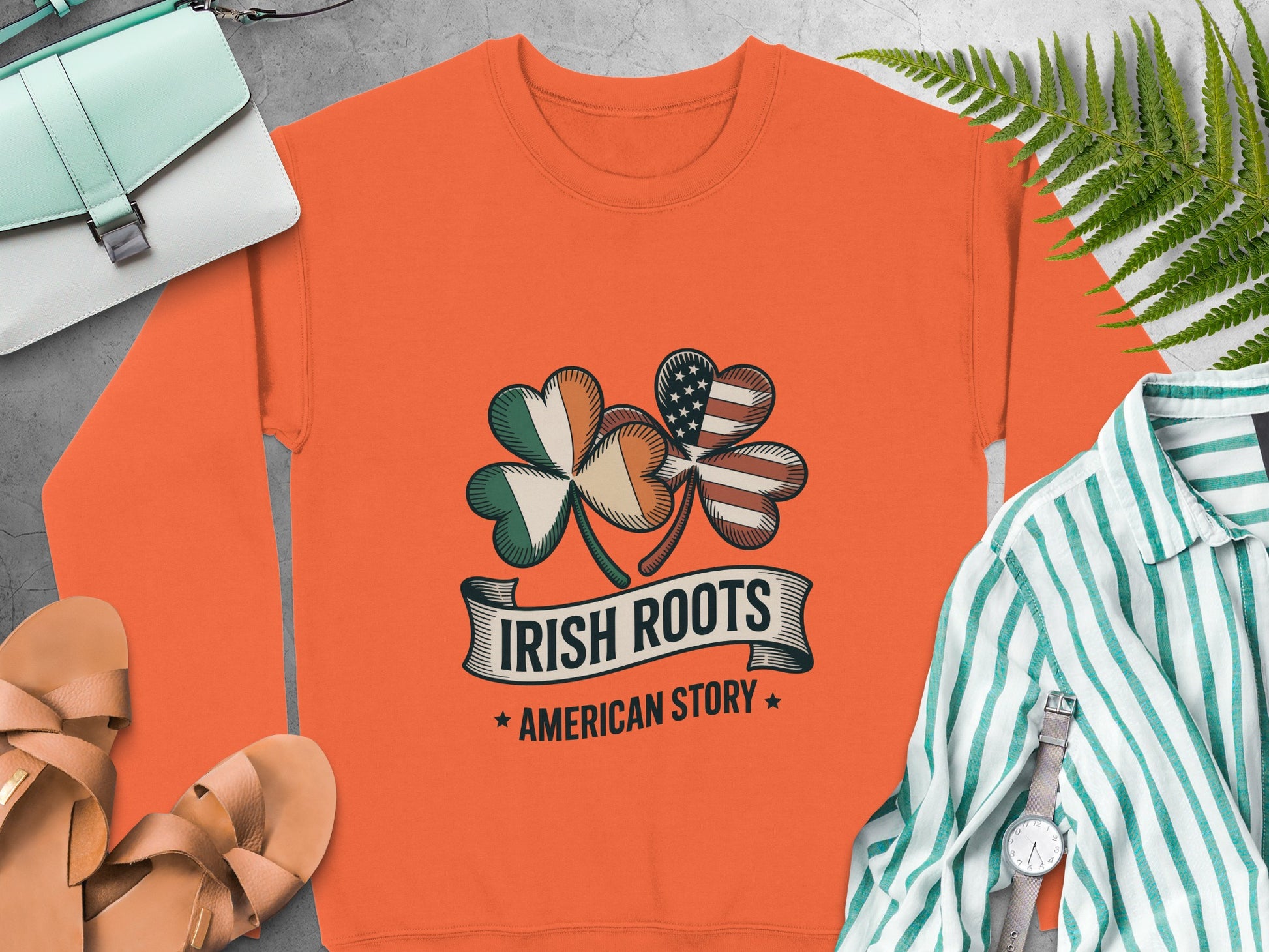 Orange sweatshirt with shamrock design, text reads "Irish Roots American Story".