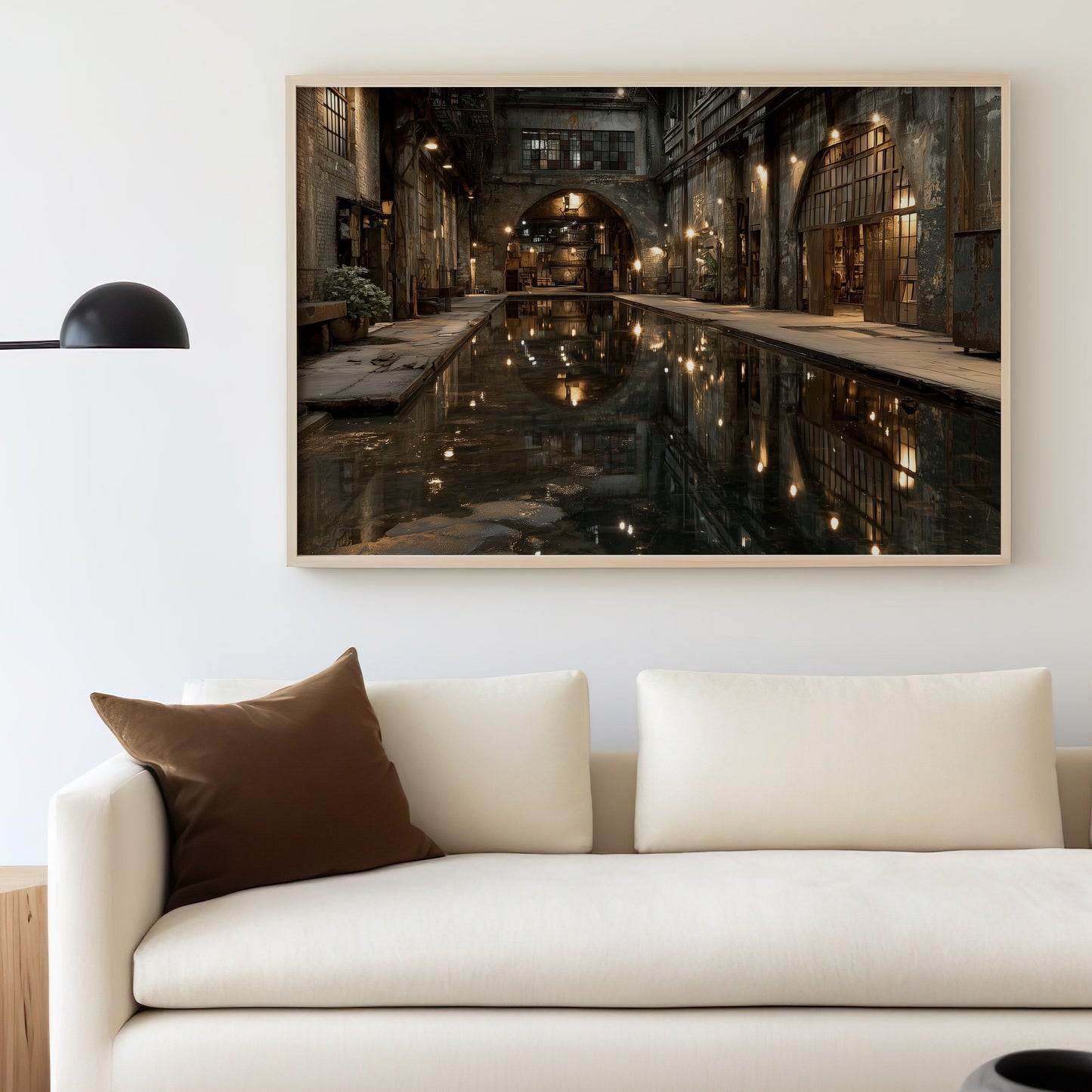 Industrial-themed artwork hangs above a cream sofa with a brown pillow.