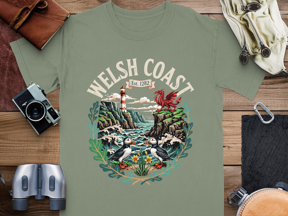 Green t-shirt with Welsh Coast graphic featuring puffins, lighthouse, dragon, and cliffs.