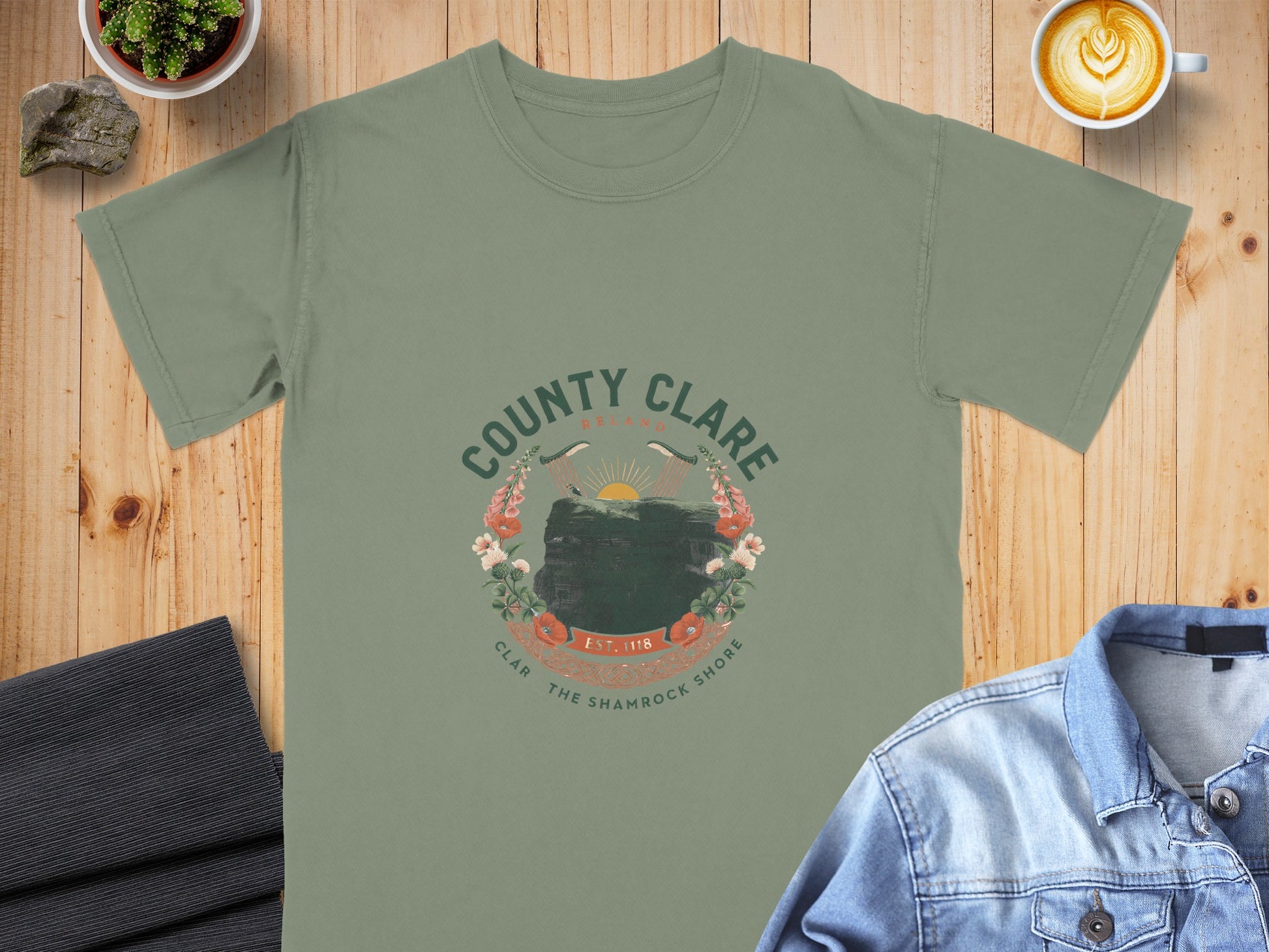 Green t-shirt with circular County Clare Ireland design featuring cliffs and flowers.