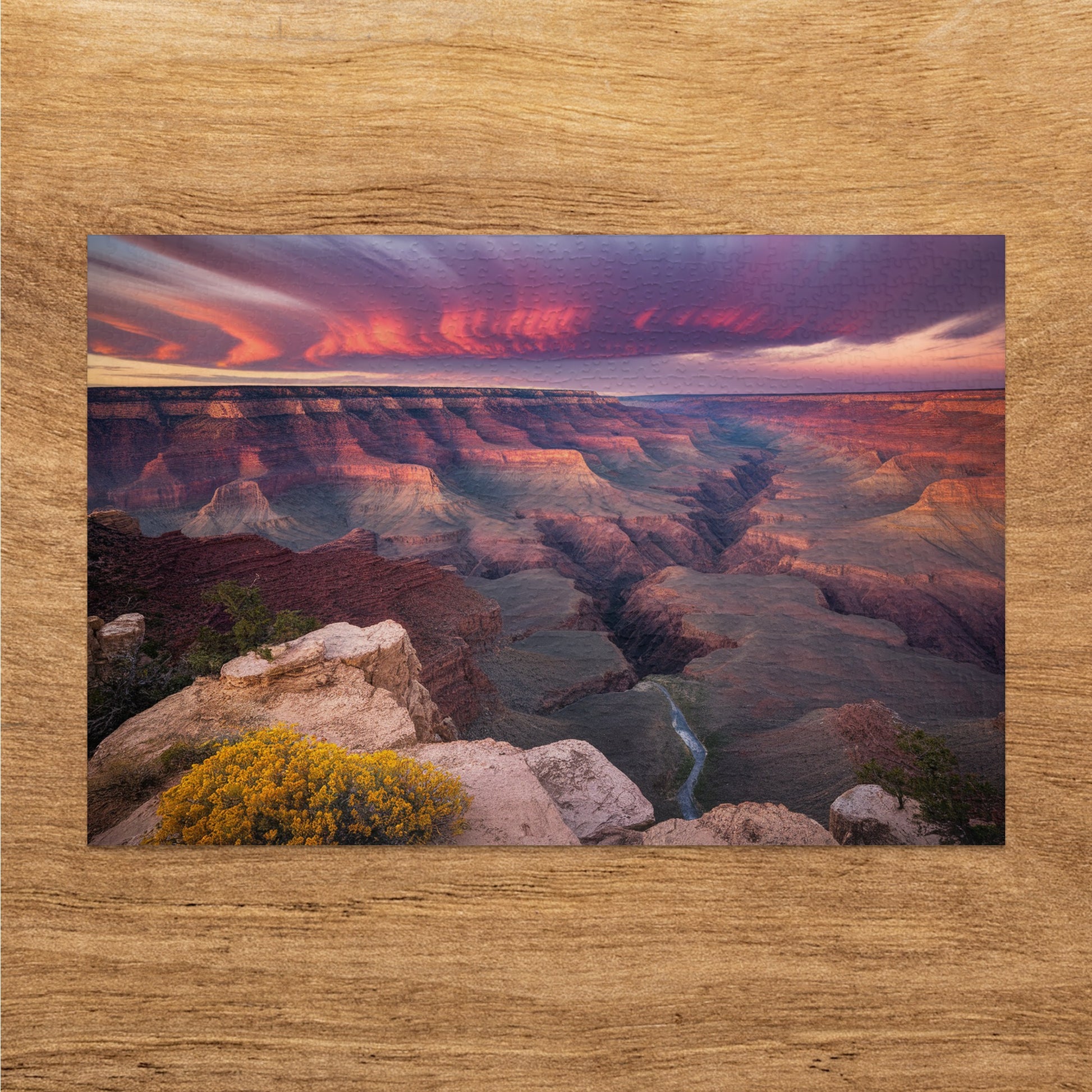 Sunset over Grand Canyon with colorful clouds and layered rock formations.