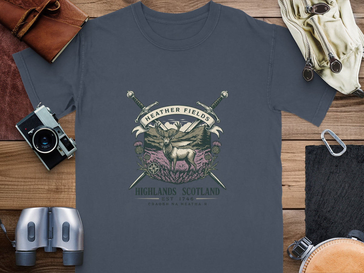 Dark grey t-shirt with a circular graphic featuring a stag, heather, swords, and "Heather Fields" text.