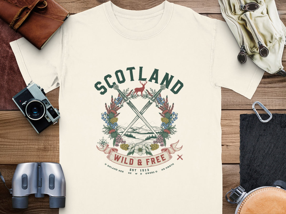 Cream t-shirt with Scotland graphic featuring crossed swords, deer, and text "Wild & Free".