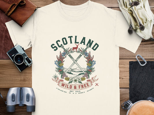 Cream t-shirt with Scotland graphic featuring crossed swords, deer, and text "Wild & Free".