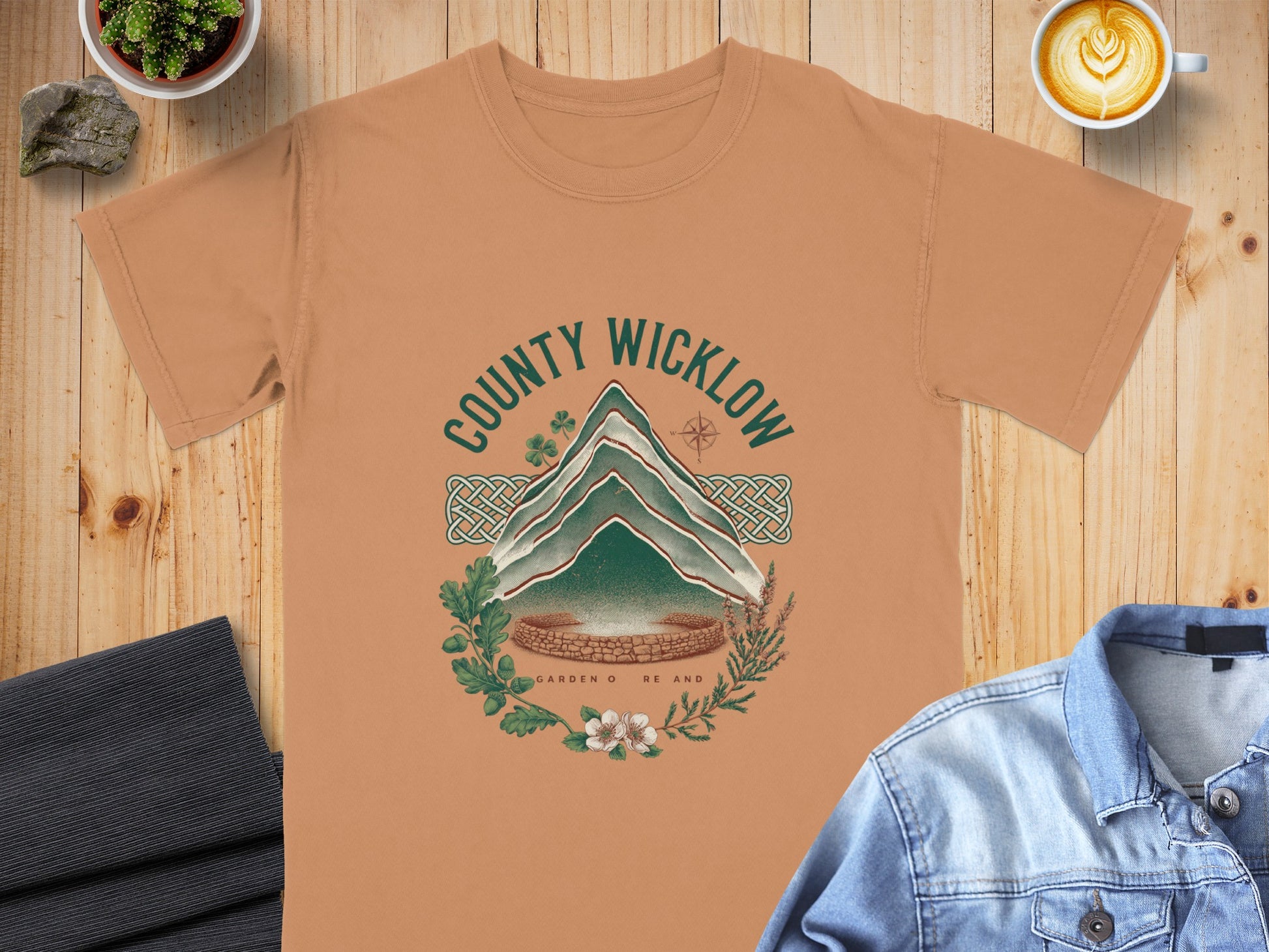 Orange t-shirt with a green graphic of a mountain, text "County Wicklow", and floral elements.