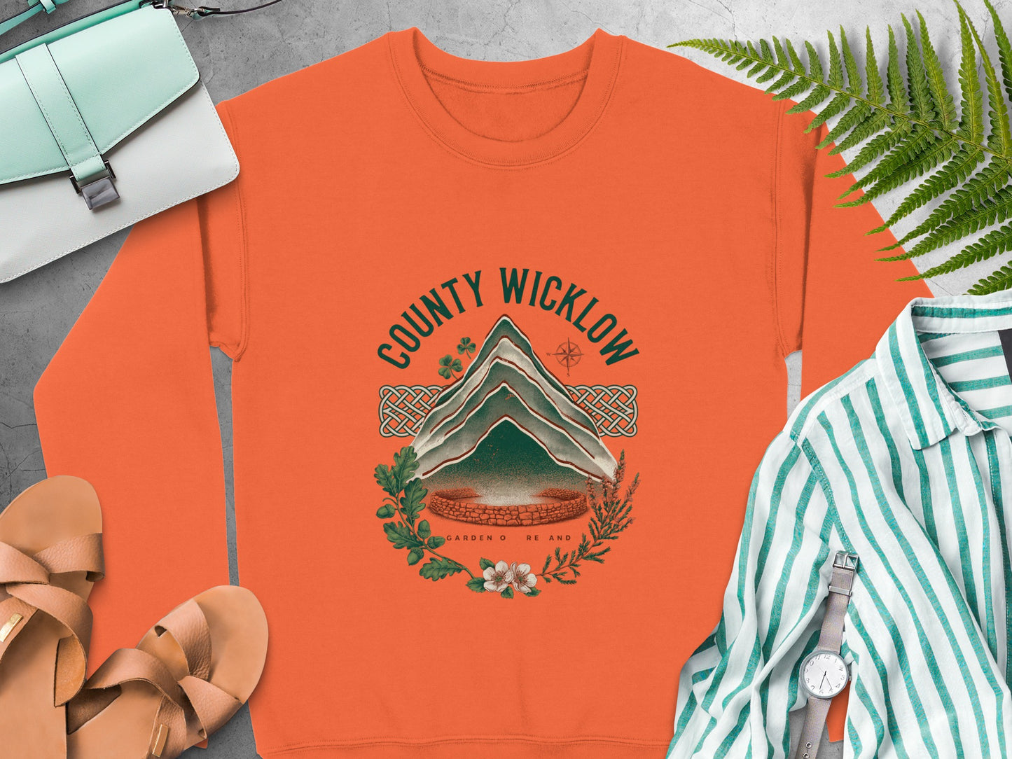Orange sweatshirt with "COUNTY WICKLOW" graphic featuring a mountain and botanical elements.