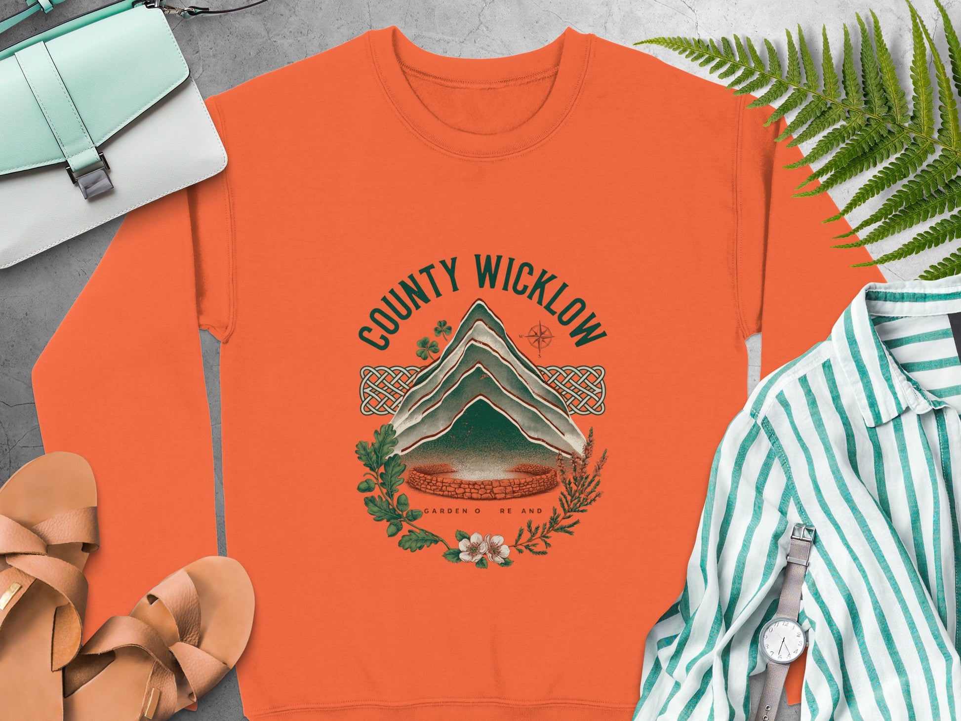 Orange sweatshirt with "COUNTY WICKLOW" graphic featuring a mountain and botanical elements.
