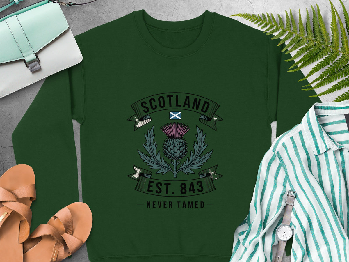 Green sweatshirt with Scotland thistle crest, "EST. 843 NEVER TAMED" text.