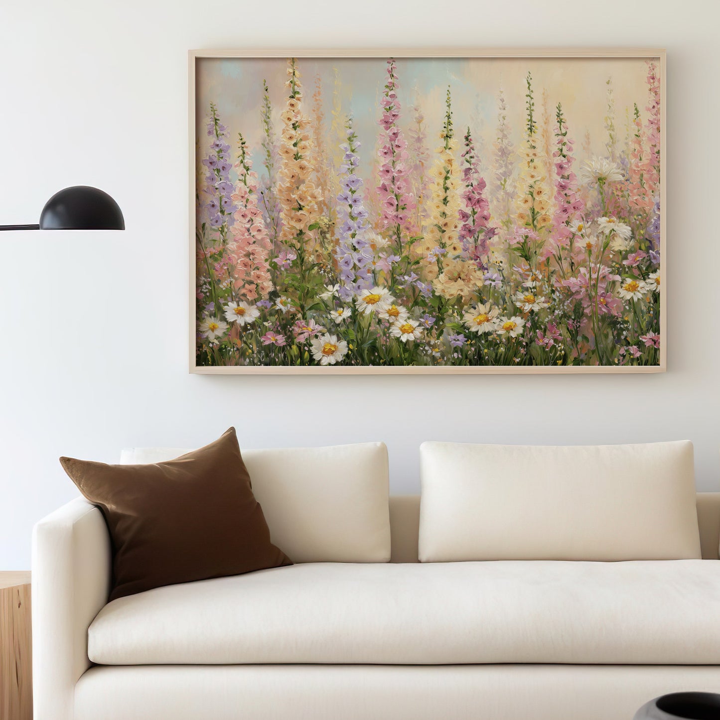 Floral painting with tall, colorful wildflowers above a cream sofa.