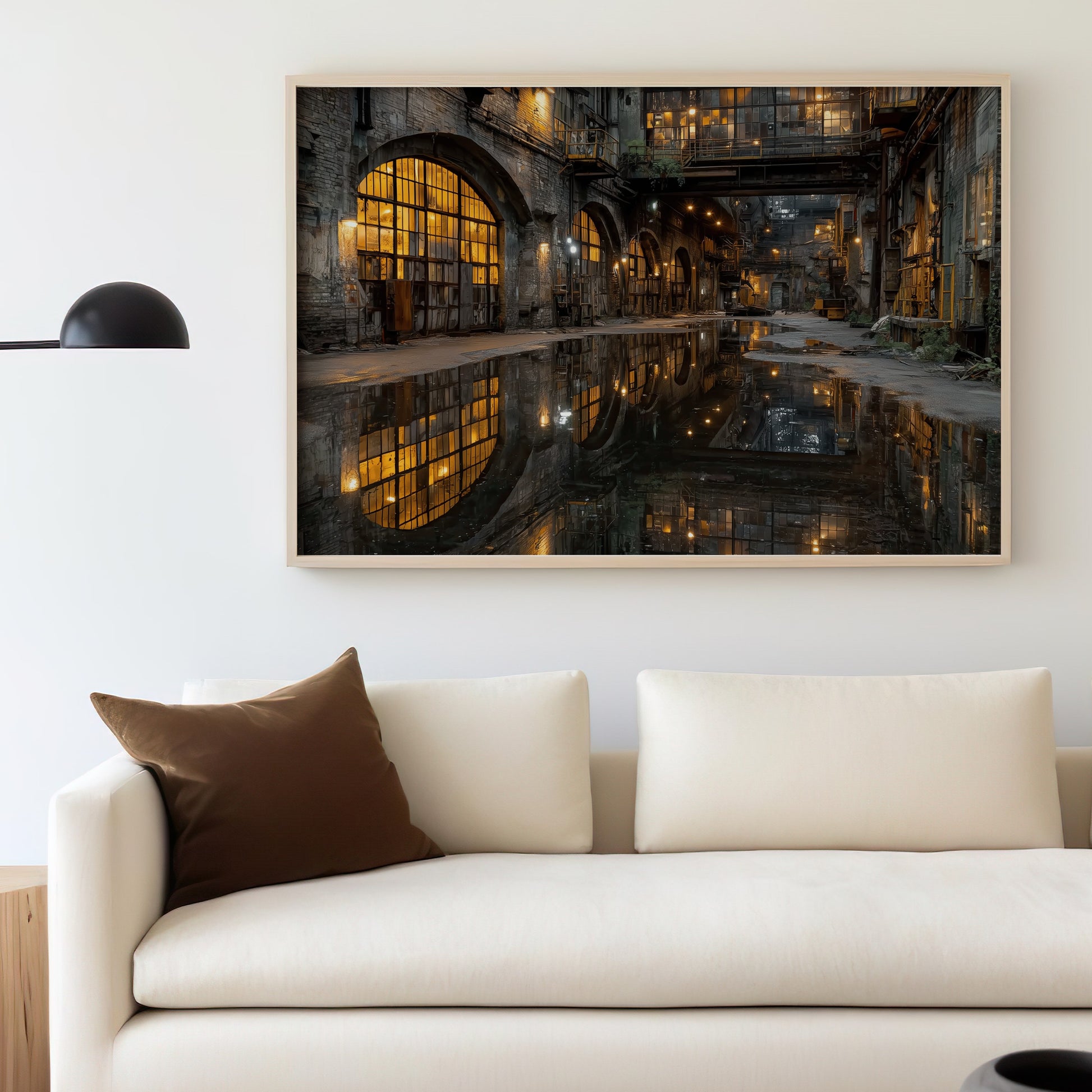 Industrial cityscape at night reflected in water on a large framed print above a sofa.