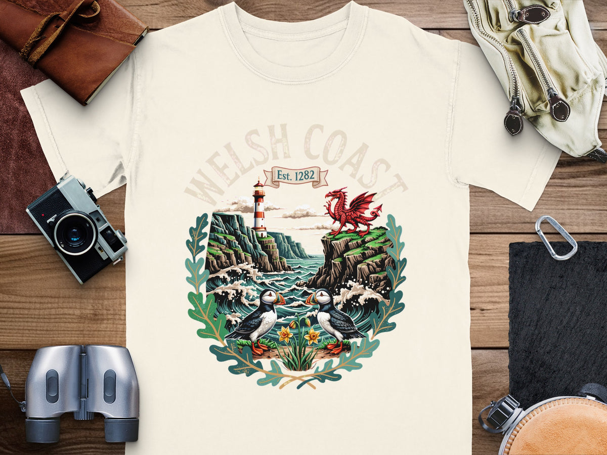 T-shirt graphic: Welsh Coast Est. 1282, two puffins, lighthouse, and dragon.