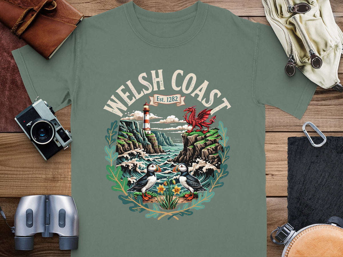 T-shirt graphic with puffins, lighthouse, dragon, and "Welsh Coast Est. 1282".