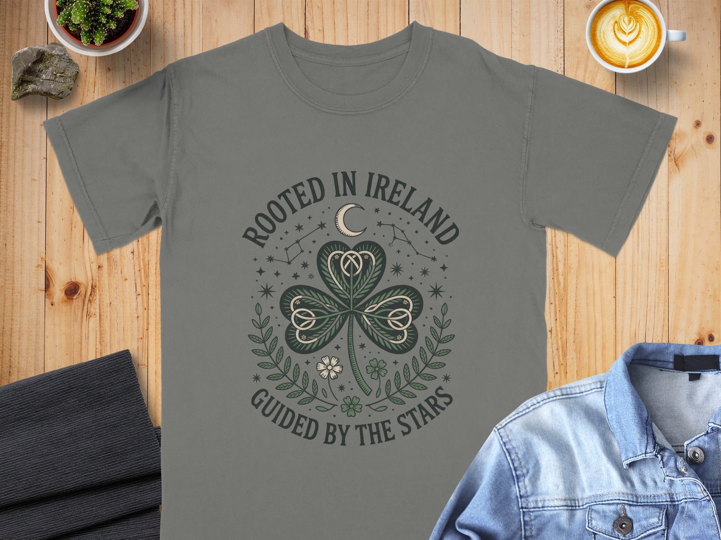 Gray t-shirt with "Rooted in Ireland Guided by the Stars" text and shamrock design.