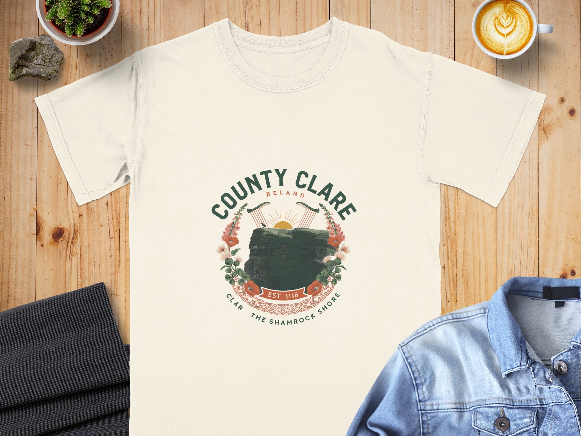 Cream t-shirt with "County Clare Ireland" crest featuring cliffs, harps, flowers, and "Est. 1118".