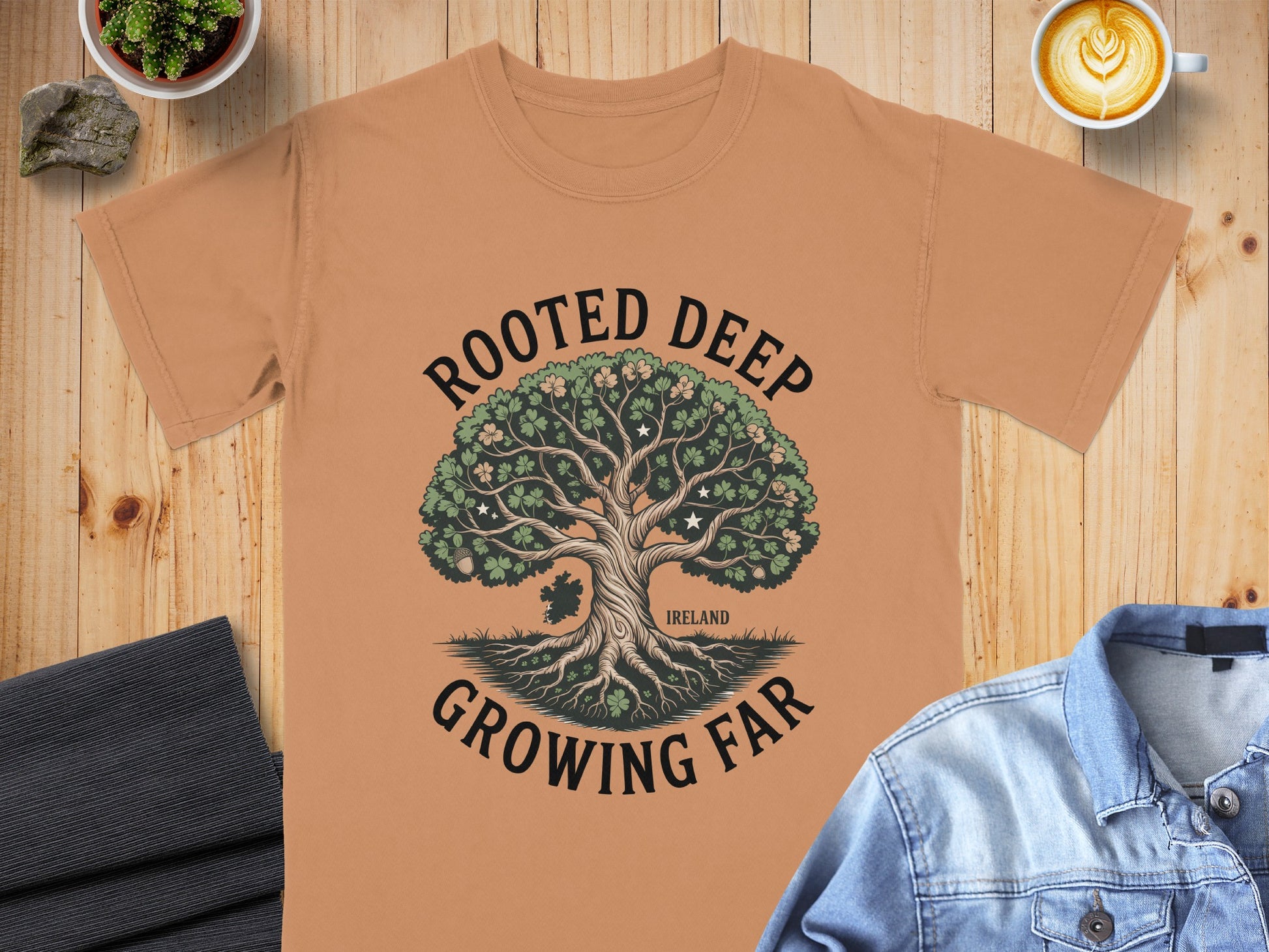 T-shirt with "Rooted Deep Growing Far" text and a stylized tree with shamrocks.