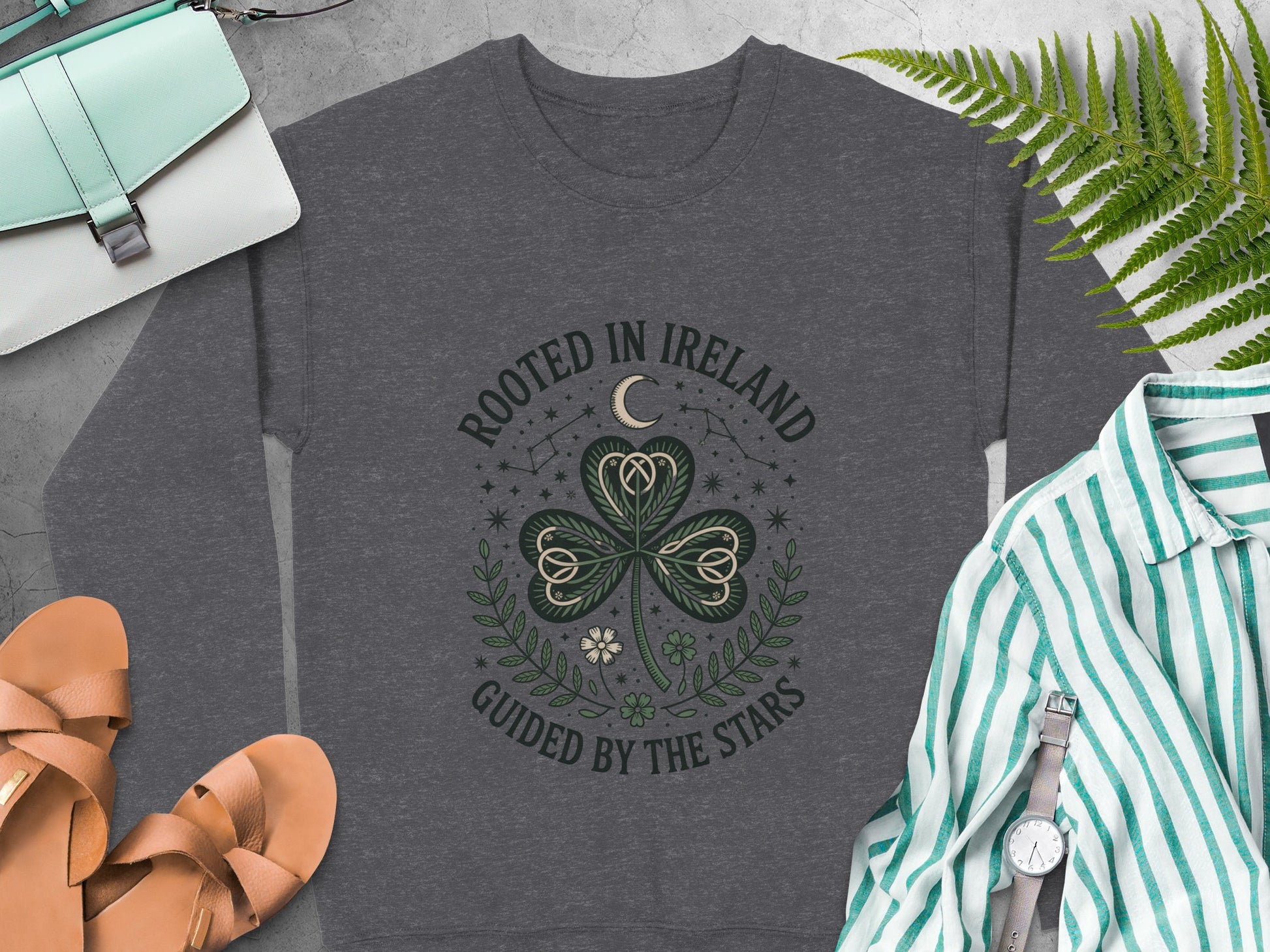 "ROOTED IN IRELAND GUIDED BY THE STARS" text and shamrock design on Dark Heather sweatshirt